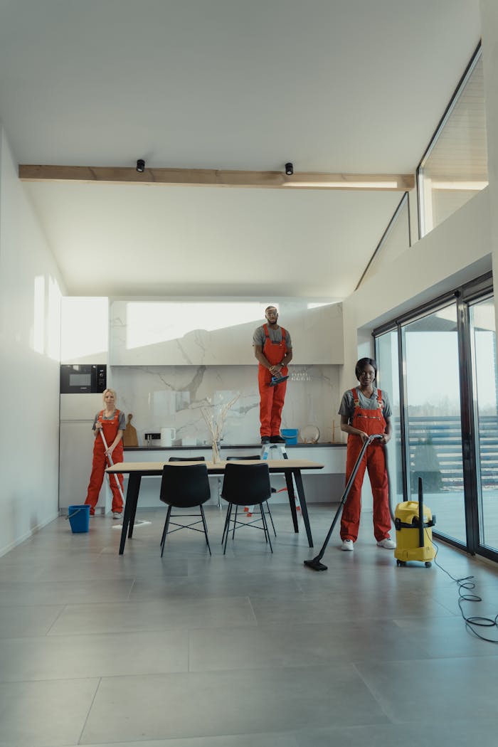 services-01 Team of professional cleaners working in a spacious, modern indoor setting.